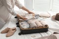 Woman packing suitcase for trip on bed, closeup Royalty Free Stock Photo