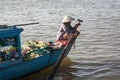 The woman with the paddle boat that carries to market fruits and vegetables from small