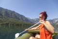 Woman paddle on calm mountain lake