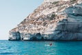 Woman paddles kayak in a calm sea in Sardinia Italy