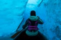 Woman paddling canoe into the ice cave of a glacier in Alaska Royalty Free Stock Photo