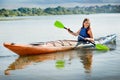 woman paddling kayak alone on lake. A girl goes on a water excursion on vacation Royalty Free Stock Photo