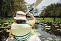 Woman paddling a kayak in the lagoon between lotus flower in pond. Royalty Free Stock Photo