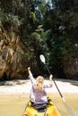 Woman paddling in kayak towards secluded tocky beach at Krabi, Thailand Royalty Free Stock Photo