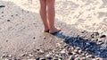 At the edge of the sea, woman`s feet/legs with the sea gently lapping them