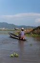 Woman paddling on a small wooden boat on inle lake in myanmar Royalty Free Stock Photo