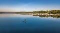 Woman paddling on SUP board on beautiful lake aerial drone view with reflections from above. Standing up paddle boarding adventure Royalty Free Stock Photo