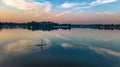 Woman paddling on SUP board on beautiful lake during sunset or sunrise, standing up paddle boarding Royalty Free Stock Photo