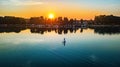 Woman paddling on SUP board on beautiful lake during sunset or sunrise, standing up paddle boarding Royalty Free Stock Photo