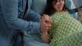 Woman in pain from childbirth holding hands with husband Royalty Free Stock Photo