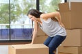 Woman moving boxes suffering backache at home