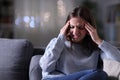 Woman in pain suffering migraine at night at home