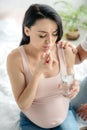 Woman with pain taking pill with water in bedroom with husband near Royalty Free Stock Photo