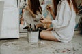 Woman painter sitting on the floor in front of mirror. Art studio interior Royalty Free Stock Photo