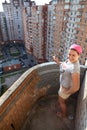 Woman painting balcony apartment on a high floor