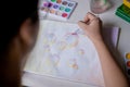 Woman painting bubble drawing with colored watercolors on a white table Royalty Free Stock Photo