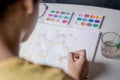 Woman painting bubble drawing with colored watercolors on a white table Royalty Free Stock Photo