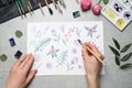 Woman painting flowers with watercolor at stone table, top view Royalty Free Stock Photo