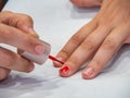 A woman painting her nails with red nail polish. Royalty Free Stock Photo