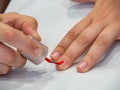 A woman painting her nails with red nail polish. Royalty Free Stock Photo