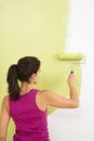 Woman painting wall.