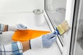 Woman painting window frame at home