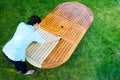 Woman painting wooden exotic wood table in the garden with a brush