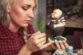 Woman paints a little plump little man