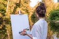 woman paints picture landscape, girl artist, view back, summer park lake pond river, white shirt , creating creativity