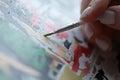 Woman paints picture with watercolors and holds brush