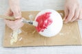 Woman paints on red color a styrofoam ball