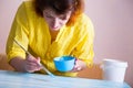 Woman paints wooden boards with a brush. Royalty Free Stock Photo