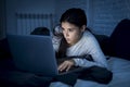 Woman in pajamas on bed at home bedroom working concentrated with laptop computer late at night Royalty Free Stock Photo