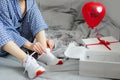 Woman in pajamas ties the laces of athletic shoes. Valentine`s D