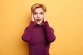 Woman with palms on her head and wide open mouth looking at camera Royalty Free Stock Photo