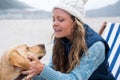 Woman pampering dog while sitting on chair