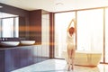 Woman in panoramic gray bathroom corner Royalty Free Stock Photo