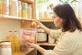 Woman in pantry taking onions, food storage in pantry on wooden shelf