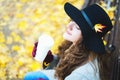 Woman with a paper cup sitting in autumn park. Royalty Free Stock Photo