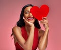 Woman, paper heart and smile in studio portrait for makeup, beauty or romantic sign by red background. Happy girl