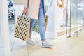 Woman with paper shopping bags walking in modern mall. Girl carrying shopping bags while walking at store. Royalty Free Stock Photo