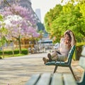 Woman in Paris, reading a book near the Eiffel tower Royalty Free Stock Photo