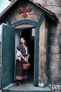 A woman parishioner at the door of an old Church in wild West America