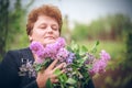 Woman in park with a big bouquet of a lilac