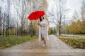 Woman in the park dancing under a red umbrella in the rain Royalty Free Stock Photo