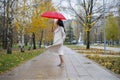 Woman in the park dancing under a red umbrella in the rain Royalty Free Stock Photo