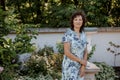 Woman in park.. Senior Working In Garden. Close-up portrait of an older woman on walk with flowers. Royalty Free Stock Photo