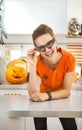 Woman in party bat glasses in the Halloween decorated kitchen Royalty Free Stock Photo