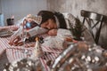 Woman in party hat sleeping peacefully on uncleaned festive table, resting after New Years Eve party Royalty Free Stock Photo