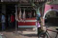 A woman passing in front of a butcher shop, in the city of El Jadida